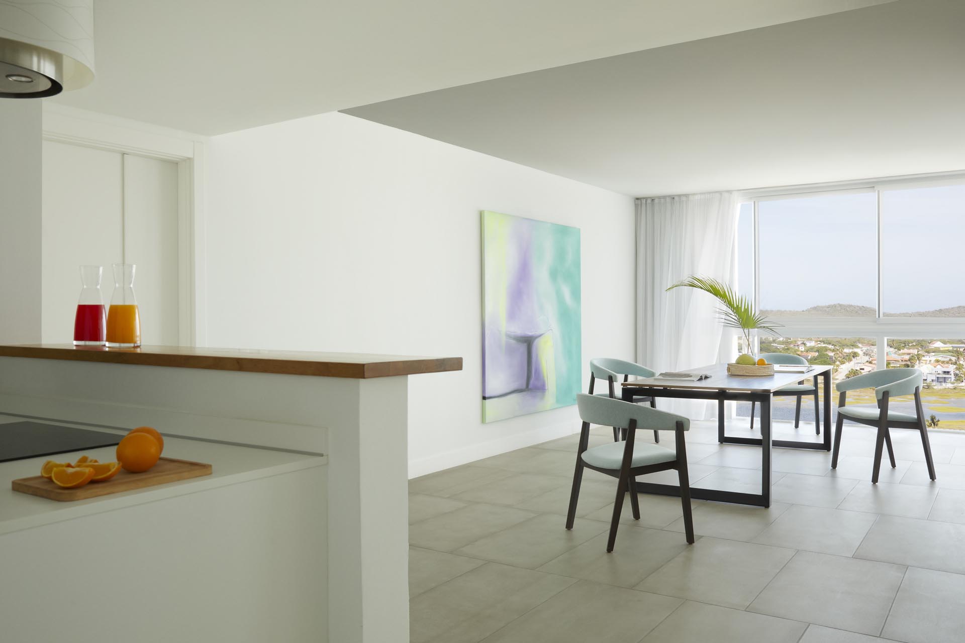 Dining room table with chairs and colorful artwork