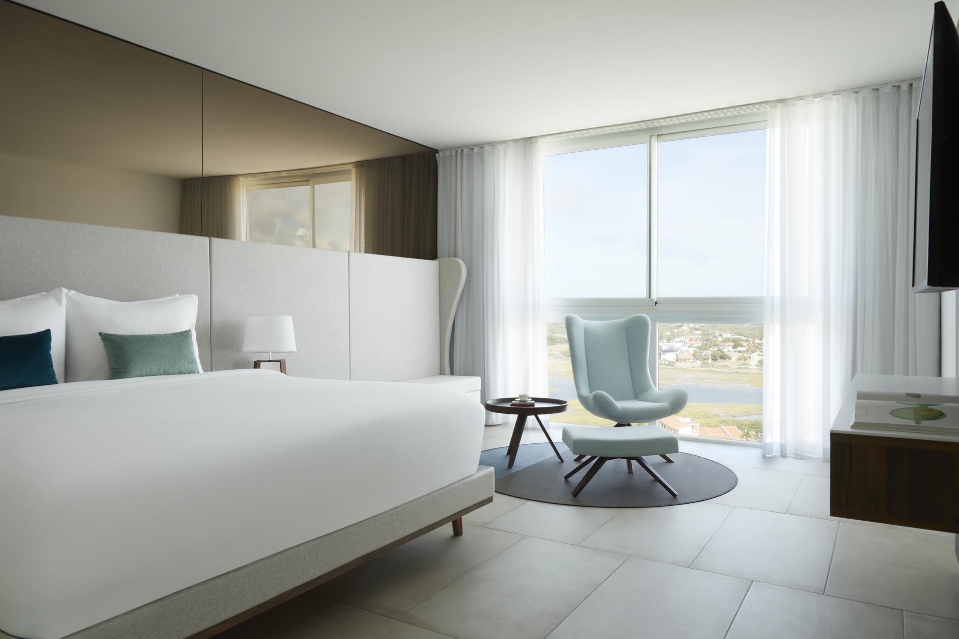 King bed with seating area and mounted TV